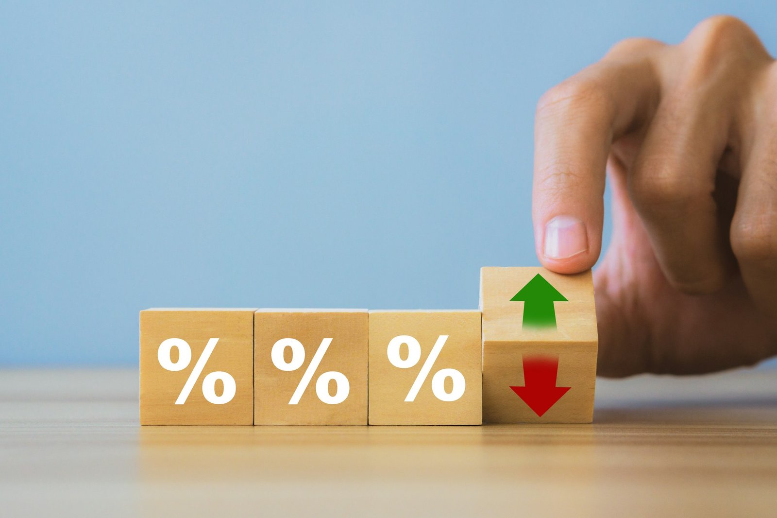 Interest rateand dividend concept.Hand holding wooden block with arrow and percentage symbol